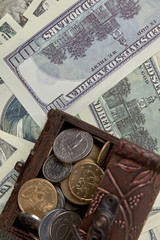 Coins of the united states in brown money box. Paper dollars background. Top view, flat lay.