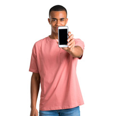 Young african american man looking at the camera and smiling while using the mobile on isolated white background