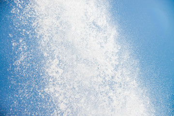 Strong flow of water on blue sky background, closeup
