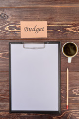 Clipboard with pencil and cup of coffee. Budget concept flat lay, overview.