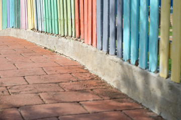 Colorful wood fence on the red brick walkway