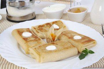 Pancakes with cottage cheese for tea with honey, sour cream and lemon.