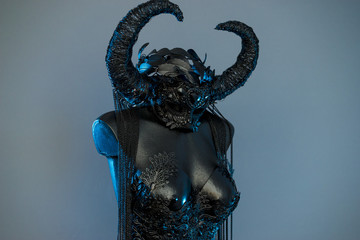 Magic Witch. Black dress with helmet of big dark horns. pieces of metal and corset of rhinestones and lace