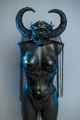 Witch. Black dress with helmet of big dark horns. pieces of metal and corset of rhinestones and lace