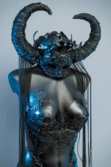 Ritual Witch. Black dress with helmet of big dark horns. pieces of metal and corset of rhinestones and lace