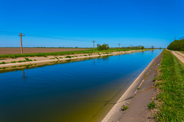 Fototapeta na wymiar long irrigation channel among a prairies