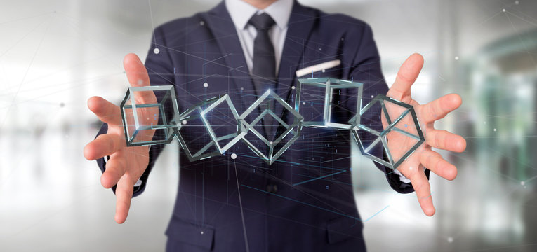 Businessman holding a 3d rendering blockchain cube isolated on a background