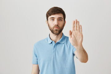 Body language and emotions concept. Calm and determined caucasian guy showing stop gesture with...