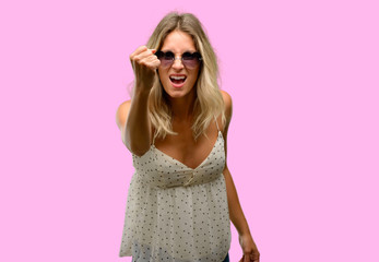Young woman wearing sunglasses with heart shape irritated and angry expressing negative emotion, annoyed with someone