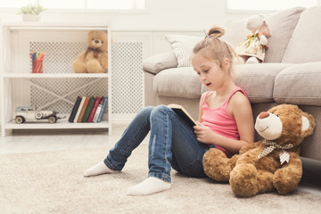 Lttle girl and her teddy bear reading book
