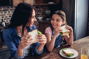 mother and daughter holding sandwiches