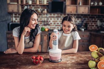 mother and daughter preparing smoothie