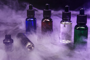 jars of liquids for vape in multi-colored smoke