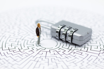 Miniature people: Businessman with master key encoding, secret code in maze. Image use for background security system, hack, business concept.