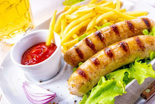 grilled bratwurst with chips and cold beer