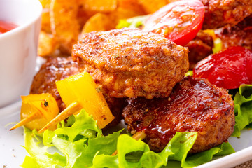 Meatballs skewers of tomato, paprika and baked potato quarters