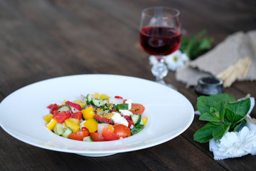 flowers, wine and salad from vegetables on old wooden table