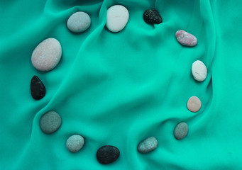Summer concept background texture with copy space. Pebbles in a circle. Aqua color