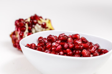 Pomegranate seeds close up on white background