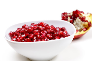 Pomegranate seeds close up on white background