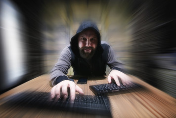 The hacker in the hood sits and works
