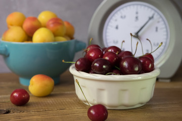Cherries and apricots in a bowl on a wooden table