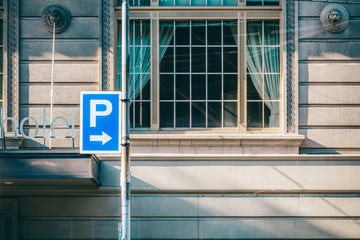 Fototapeta na wymiar Parking sign with arrow pointing to right ini front of old historic building and window in Melbourne, Australia