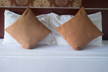Brown pillows on bed in classic bedroom