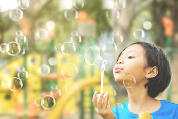 Pretty little girl playing with soap bubbles