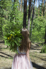 Fototapeta na wymiar Beautiful lady with bouquet of fern in the forest.