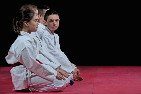 Children in kimono sitting on tatami on martial arts seminar. Selective focus.