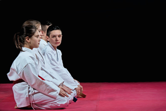 Children in kimono sitting on tatami on martial arts seminar. Selective focus.