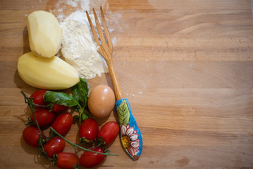 ingredients for gnocchi: flour, potatoes, an egg and tomatoes for the sauce