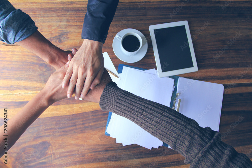 Wall mural Meeting teamwork concept,Friendship,Group people with stack of hands showing unity after successful negotiations at office