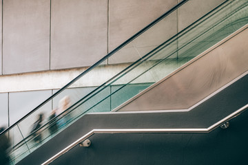 Obraz premium Blurred motion of people on escalator with copy space - toned image