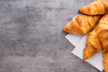 Tasty buttery croissants on old graye table.