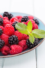 Fresh raspberries in a plate on a  vintage background.