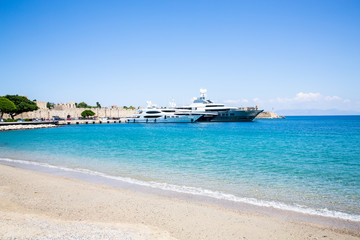 Fototapeta na wymiar Sand beach and modern yachts in Rhodes Town, Rhodes Island, Mediterranean Sea, Greece