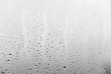 Raindrops on the window glass, gray background.