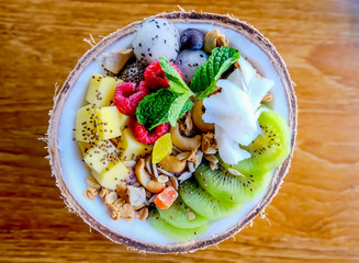 Healthy food: Yogurt and Mixed Fruit in Coconut shell : Coconut, dragon fruit, grape, kiwi, cashew nut, berry, mango, peanut, coconut