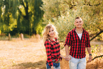 Young couple dressed in identical red shirts, walking outdoors.