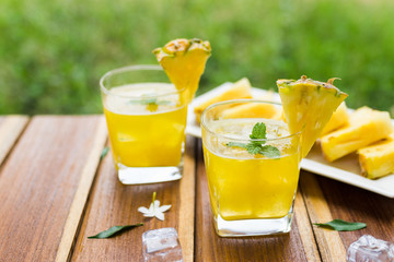 Pineapple fruits drink on wooden background.