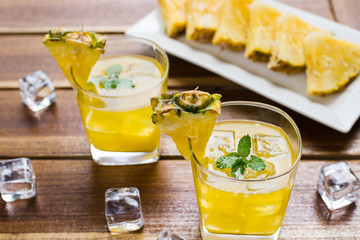 Pineapple fruits drink on wooden background.