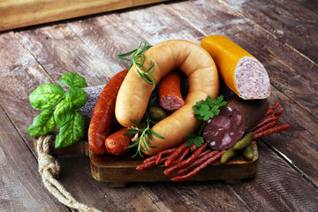 Food tray with delicious salami, ham,  fresh sausages, cucumber and herbs. Meat platter
