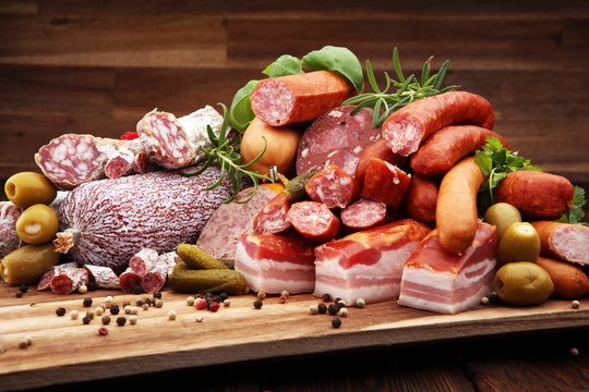 Food tray with delicious salami, ham,  fresh sausages, cucumber and herbs. Meat platter