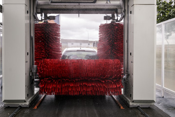 Coche lavándose en túnel de lavado de un lavadero de coches