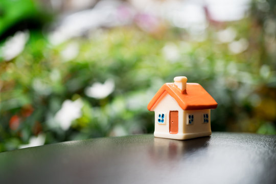 Miniature house with copy space on green nature background using as property and family concept