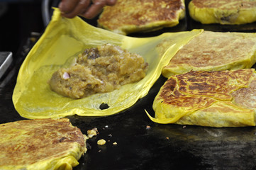 Malaysian street food called Murtabak. Cook by Hawkers. In it there is a mixture of meat, eggs and...