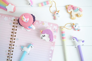 Unicorn stationery. Keeping diary with sweet unicorn pens and pencils with cute macarons and cookie. Little girl's diary. Day dreaming concept