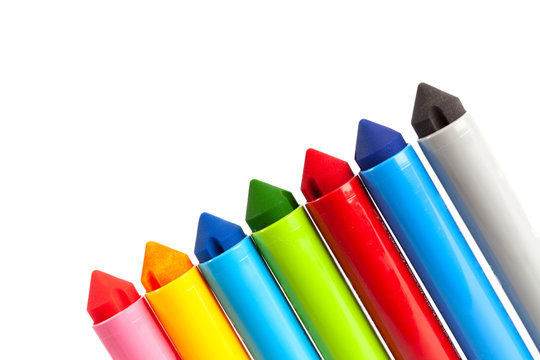 Diagonal row of chunky large kids markers on white background with copy space